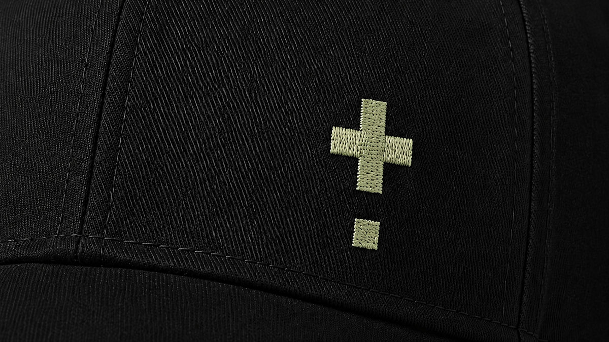 Close-up of the black Vanture Core Icon Cap featuring the embroidered green Vanture icon on the front.