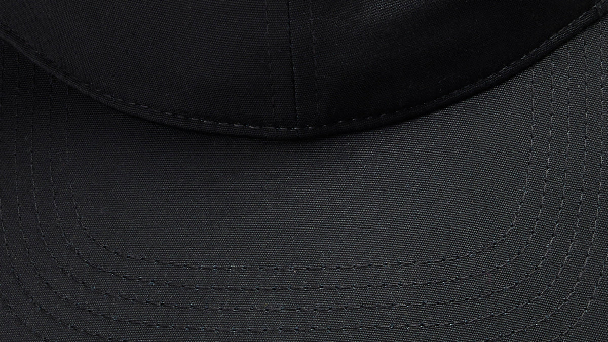 Close-up detail of the black Vanture Icon Cap showing the fabric texture, curved brim and stitching.