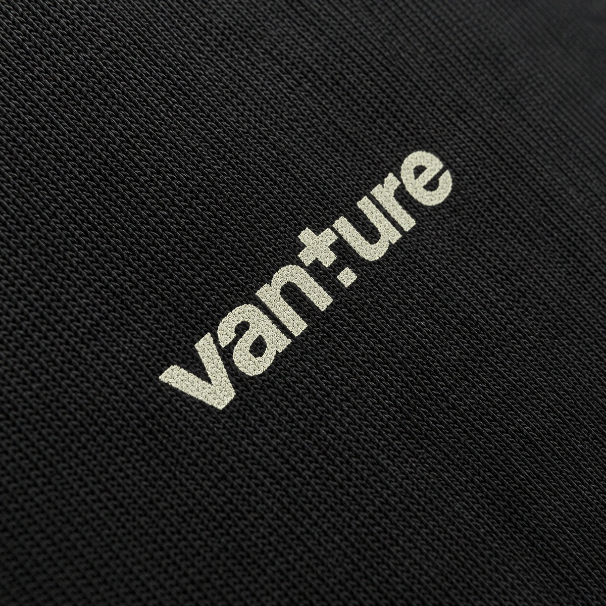 Close-up of Vanture chest logo printed in off-white on black heavyweight cotton T-shirt