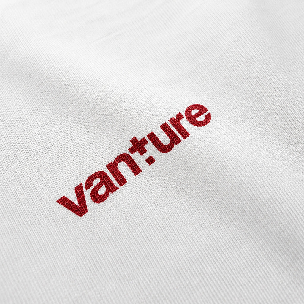 Close-up of the Vanture T1 Era T-shirt logo printed in Sealing Wax Red on white fabric