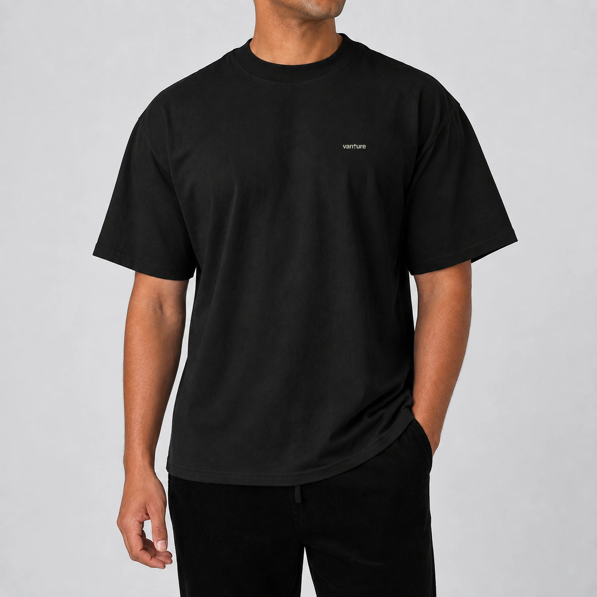 Model wearing the black Vanture T2 Era T-shirt with small chest logo