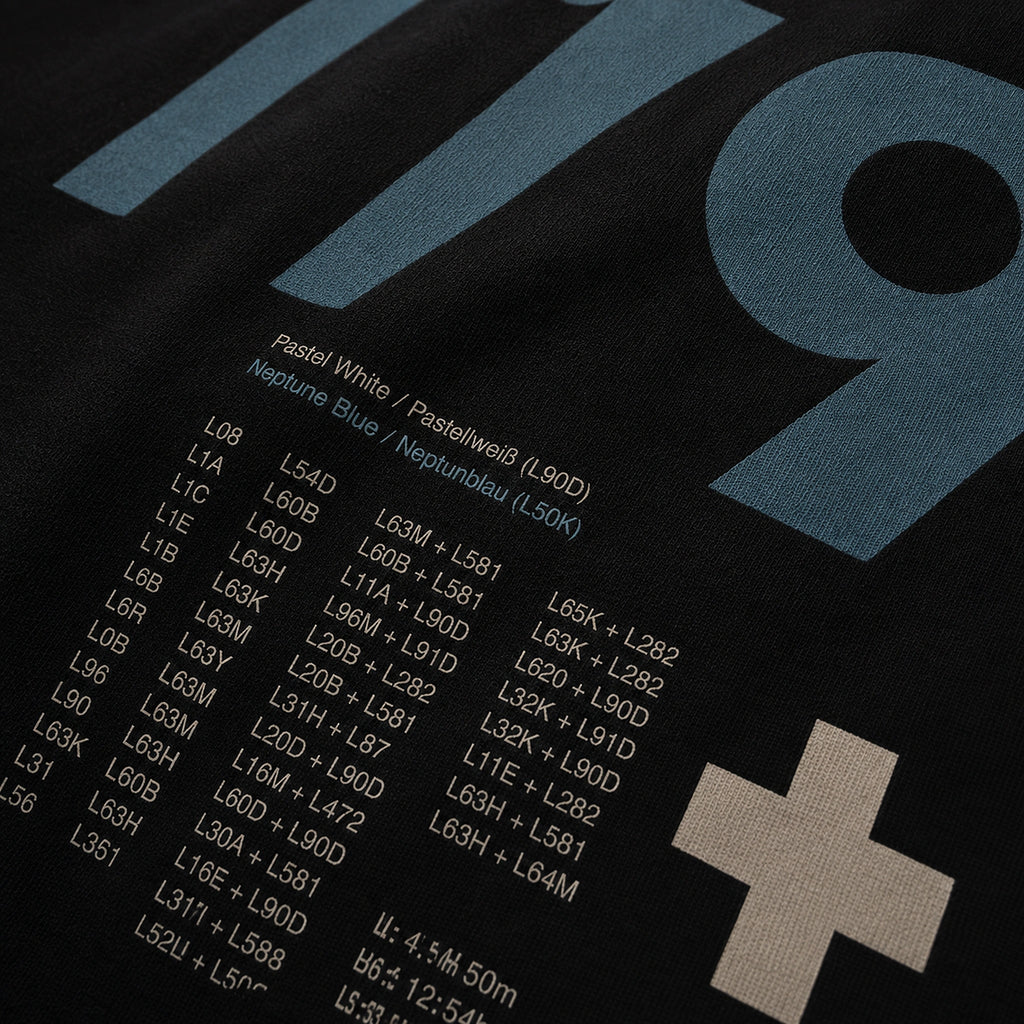 Close-up of the Vanture T2 Era T-shirt back print showing Neptune Blue and Pastel White colour references on black cotton fabric