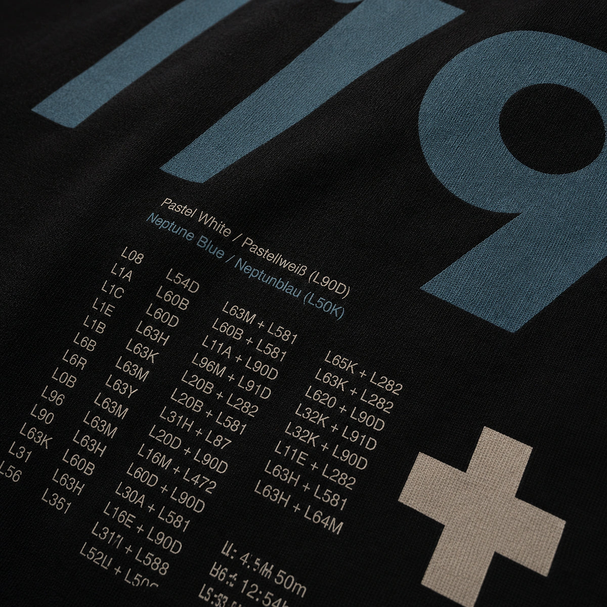 Close-up of the Vanture T2 Era T-shirt back print showing Neptune Blue and Pastel White colour references on black cotton fabric