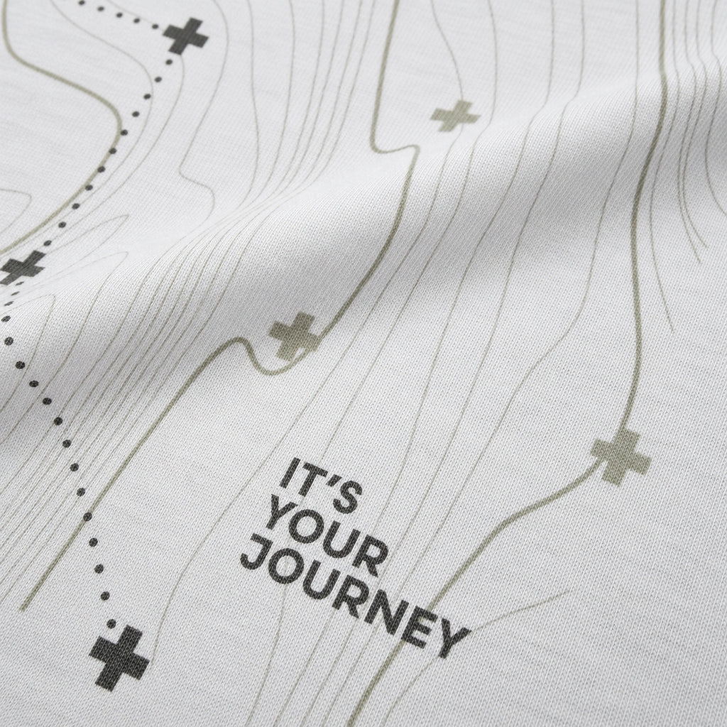 Close-up of the Vanture Your Journey T-shirt graphic showing route lines, vanture icons and It's Your Journey text on white cotton fabric
