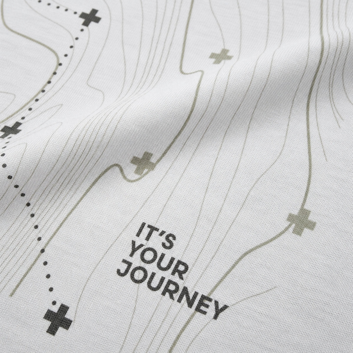 Close-up of the Vanture Your Journey T-shirt graphic showing route lines, vanture icons and It's Your Journey text on white cotton fabric