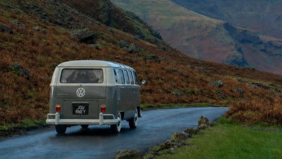 Vintage Volkswagen T1 campervan driving along a mountain road