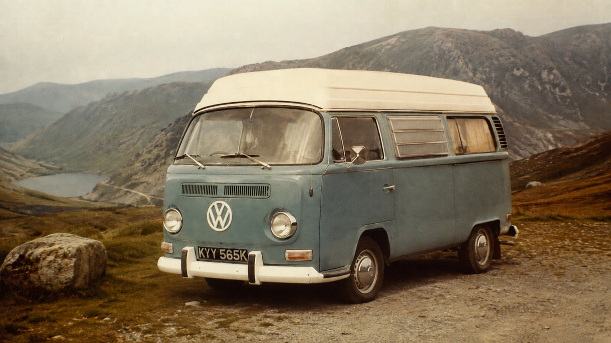 Vintage Volkswagen T2 campervan parked beside a mountain lake